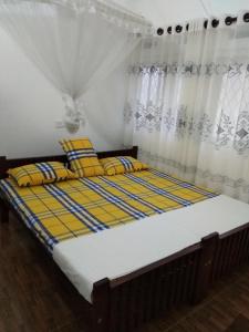 Una cama con almohadas amarillas y azules en un dormitorio en Leisure in Galle en Galle
