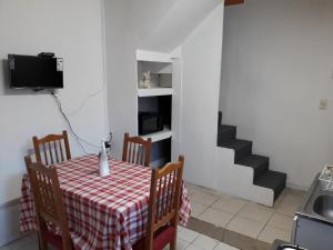 a dining room with a table and chairs and a staircase at Departamento a minutos del centro in Puerto Montt