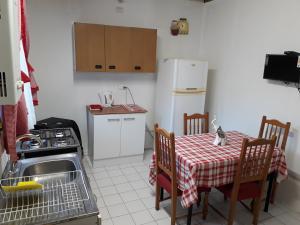 a small kitchen with a table and a white refrigerator at Departamento a minutos del centro in Puerto Montt