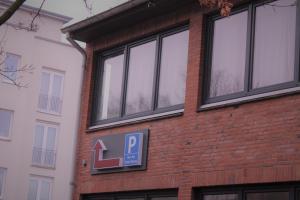 a brick building with a parking sign on it at Pionier Hotel Hamburg Wandsbek in Hamburg