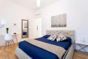 sypialnia z niebieskim łóżkiem i białą ścianą w obiekcie BB4U Apartments w mieście Palermo