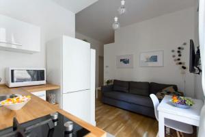 a kitchen and a living room with a couch at BB4U Apartments in Palermo