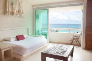 a bedroom with a bed and a view of the ocean at Rodero by Solymar Beach Front Condos in Hotel Zone in Cancún