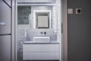 bagno con lavandino bianco e specchio di Varsovia Apartments Jaktorowska a Varsavia