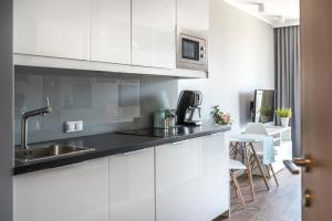 a kitchen with white cabinets and a sink at Varsovia Apartments Jaktorowska in Warsaw