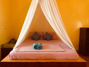 a bed with two pairs of blue shoes on it at Melbao Homestay in Gili Islands