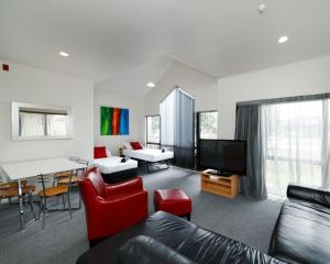 a living room with a couch and a table at Drovers Motor Inn in Palmerston North