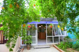 eine Eingangstür eines Hauses mit einem Orangenbaum in der Unterkunft Homestay MINH TÚ in Hue