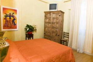 1 dormitorio con cama de color naranja y vestidor en B&B Il Sedile, en Lecce