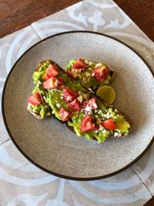 a plate with two slices of bread with lettuce and tomatoes at Captain Goodtimes in Gili Air +50 photos