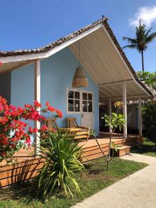 a blue house with a porch and flowers at Captain Goodtimes in Gili Islands