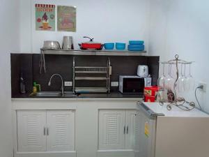 cocina con fregadero y microondas en Blue Moon House en Ko Samed