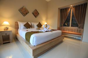 ein Schlafzimmer mit einem großen Bett und einem Fenster in der Unterkunft Uma Dhari Villa by Prasi in Ubud