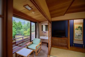 a living room with a green chair and a window at 료칸 여명 旅館 黎明 Ryokan Reimei in Yufuin +78 photos