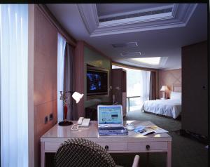 a hotel room with a desk with a laptop on it at Lake Hotel in Xindian