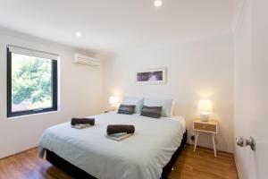 
a bedroom with a bed and a desk at Monument Hill Townhouse - Fremantle in Fremantle
