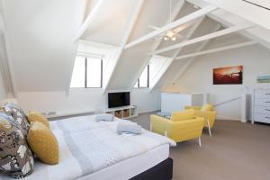
a living room with a bed, chair and a tv at Monument Hill Townhouse - Fremantle in Fremantle
