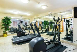 a gym with treadmills and ellipticals and mirrors at Motel 6-Alsip, IL in Alsip