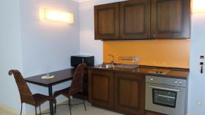 a kitchen with a table and chairs and a sink at Oasis Beach Studios in Sunny Beach