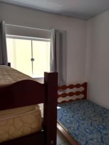 a bedroom with a bunk bed and a window at CASA TERREA PERUIBE 5 MIN DO CENTRO,LINDA VISTA, PRÓXIMO A TUDO. in Peruíbe