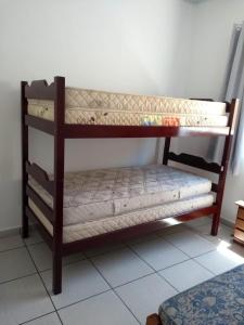 a couple of bunk beds in a room at CASA TERREA PERUIBE 5 MIN DO CENTRO,LINDA VISTA, PRÓXIMO A TUDO. in Peruíbe