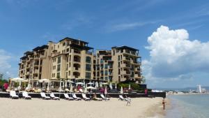 een hotel op het strand met stoelen en mensen op het strand bij Oasis Beach Studios in Sunny Beach