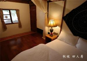 
a bedroom with a bed and a lamp at 玉蟾園民宿 寵物友善 YuChanYuan B&B in Chishang
