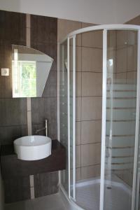 a bathroom with a glass shower and a sink at Doris Apartments in Siófok