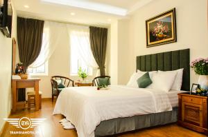 a bedroom with a large bed and a desk at Gia Loc Hotel in Hanoi
