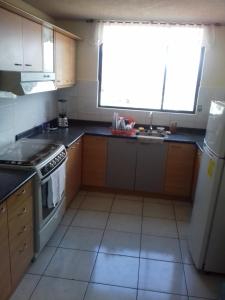 a kitchen with a stove and a sink and a window at Cerca a Mitad del Mundo in Quito