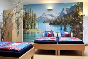 1 Schlafzimmer mit 2 Betten und einem Wandbild eines Berges in der Unterkunft Pension Jung in Leipzig