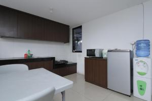a kitchen with a white table and a refrigerator at RedDoorz Plus near Plaza Indonesia in Jakarta