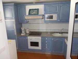 een blauwe keuken met een wastafel en een fornuis bij Marina Dor II in Cala d´Or