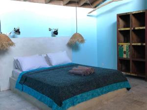 a bedroom with a bed with a blue wall at Captain Goodtimes in Gili Islands +56 photos