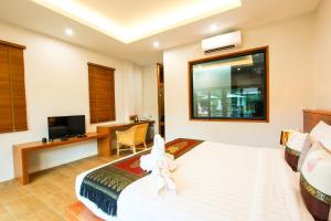 um quarto com uma cama, uma secretária e uma televisão em Verona Lanta Resort em Ko Lanta