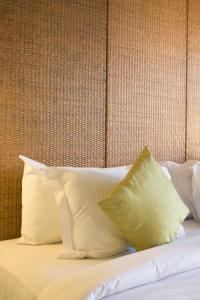 a bed with white pillows and a brown wall at Apartment Nusa Dua in Nusa Dua +39 photos