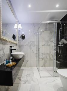 a bathroom with a glass shower and a sink at Qbic City Hotel in Larnaca
