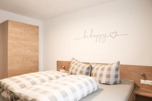 a bedroom with two beds and a sign that reads happy at Haus Lutt in Ried im Oberinntal