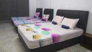 a couple of beds with pillows in a room at Gopeng TownHouse in Gopeng