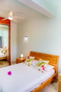 a bedroom with a bed with white sheets and a mirror at Cap-sud self catering in Au Cap