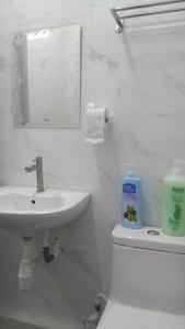 a bathroom with a sink and a toilet and a mirror at Gopeng TownHouse in Gopeng