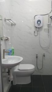 a bathroom with a shower and a toilet and a sink at Gopeng TownHouse in Gopeng