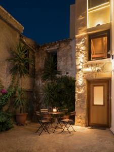 a patio with a table and chairs in front of a building at Evans House II in Chania Town