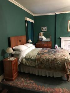 a bedroom with a large bed and a green wall at Bank Top Farm B&B Hartington in Buxton