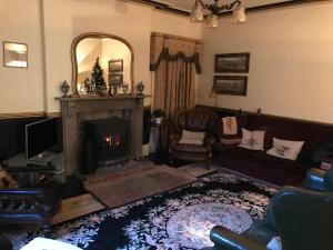 a living room with a fireplace and a couch at Bank Top Farm B&B Hartington in Buxton