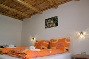 1 dormitorio con 1 cama con almohadas de color naranja en Penzión Štrba en Tatranska Strba