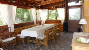 ein Esszimmer mit einem Tisch und einigen Fenstern in der Unterkunft Agriturismo Al Respiro Nel Bosco in Camporotondo di Fiastrone