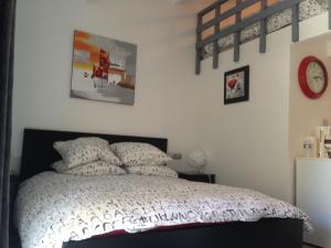 1 dormitorio con 1 cama y reloj en la pared en Le Verger de Sauvebonne, en Hyères