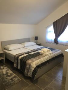 een slaapkamer met een bed en een raam bij Filipovic rent a car & apartments in Selnica Šćitarjevska