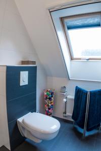 a bathroom with a white toilet and a skylight at Geranio in Made